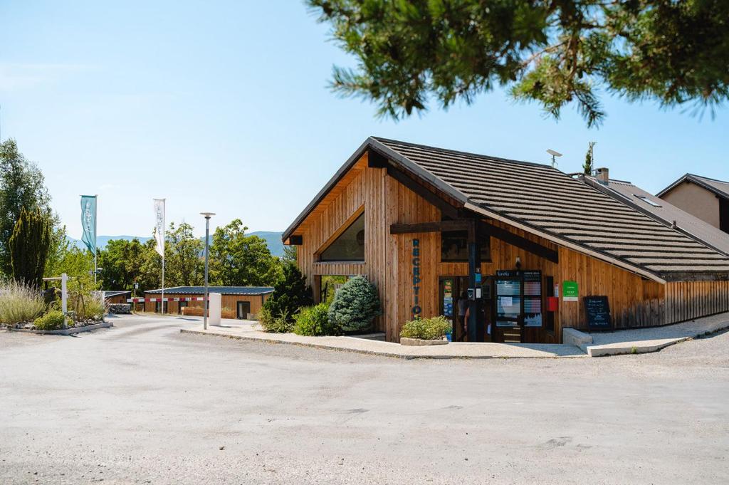 un bâtiment en bois avec un panneau en face de celui-ci dans l'établissement Glamping Hautes-Alpes, à Prunières 34 autres photos