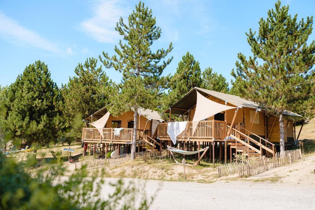 un groupe de tentes dans un champ arboré dans l'établissement Glamping Hautes-Alpes, à Prunières