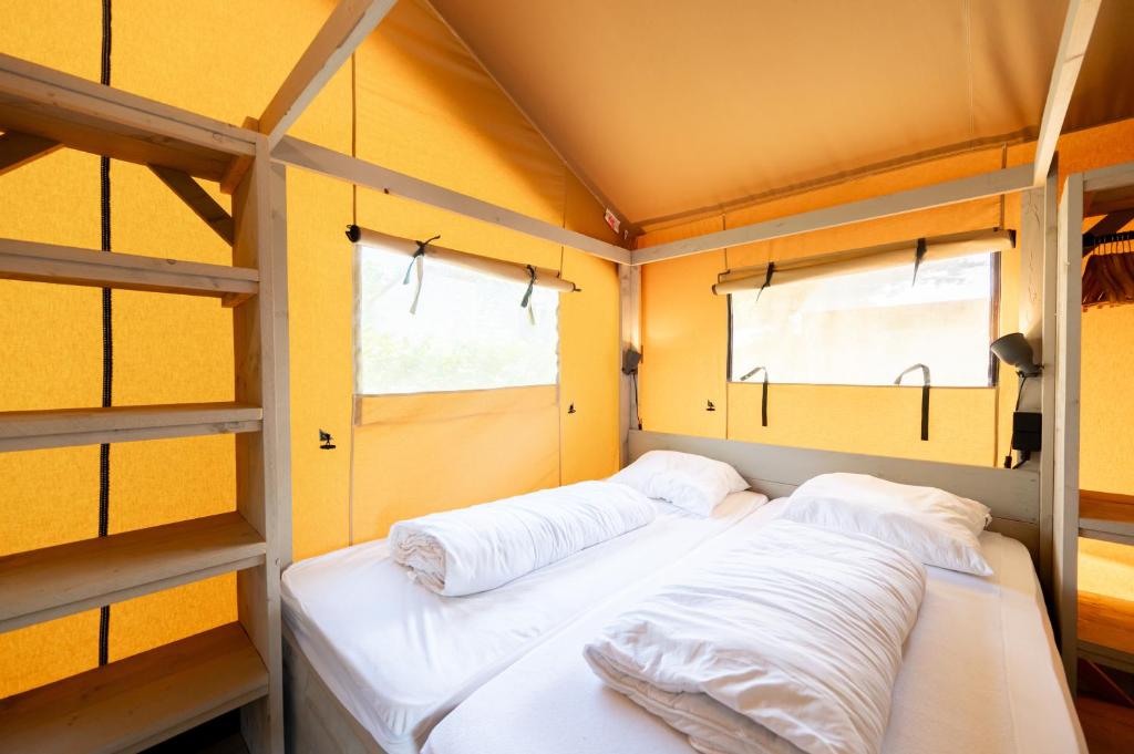 Cette chambre comprend 2 lits superposés et 2 fenêtres. dans l'établissement Glamping Hautes-Alpes, à Prunières