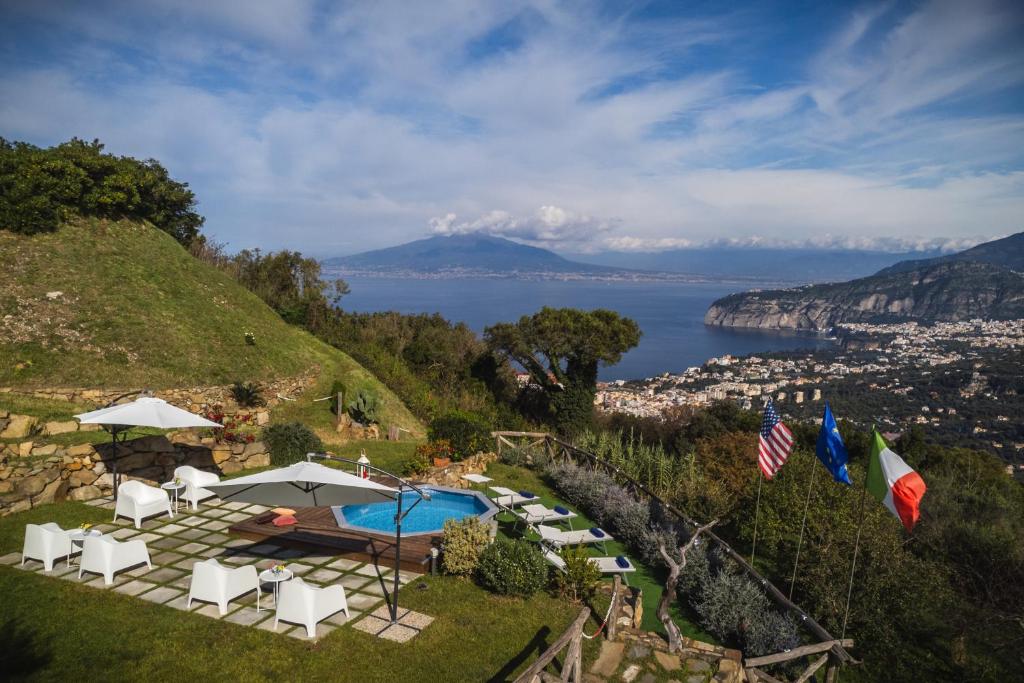 - une piscine avec des chaises et des parasols sur une colline dans l'établissement Villa dei Golfi, à SantʼAgata sui Due Golfi