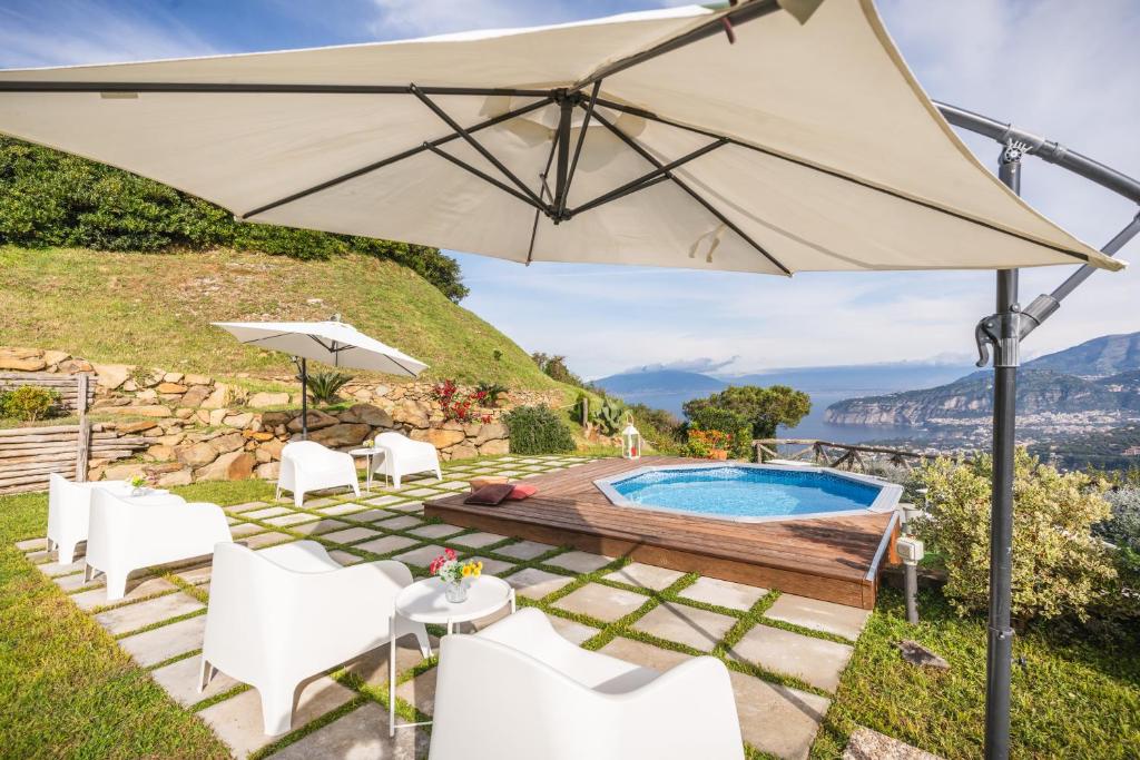 une terrasse avec une piscine et un parasol dans l'établissement Villa dei Golfi, à SantʼAgata sui Due Golfi