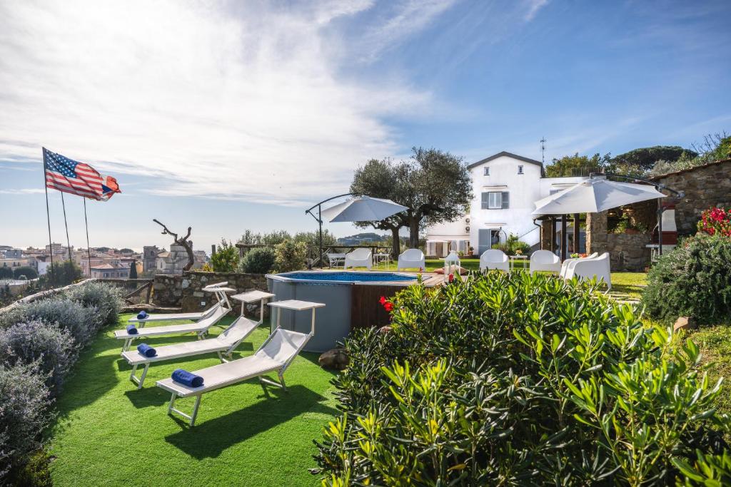 une cour avec une piscine, des chaises et un drapeau américain dans l'établissement Villa dei Golfi, à SantʼAgata sui Due Golfi