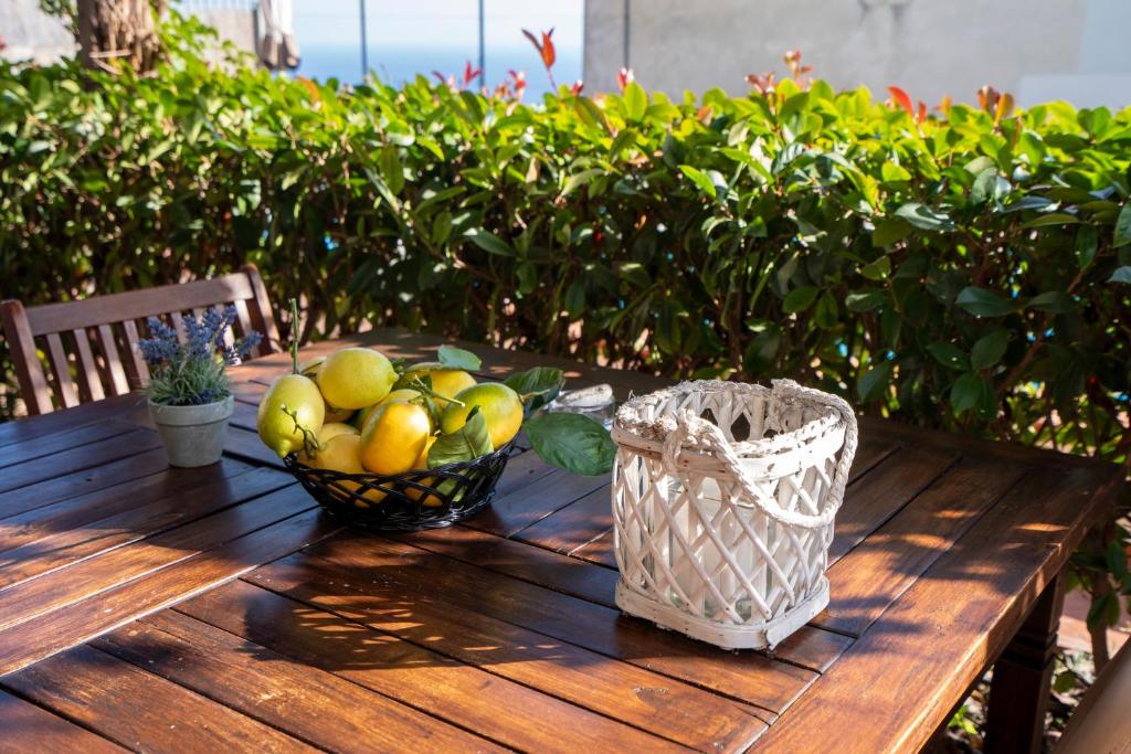 - une table en bois avec une corbeille de fruits dans l'établissement Villa Miramare, piscina e parcheggio a Conca dei Marini, à Conca dei Marini
