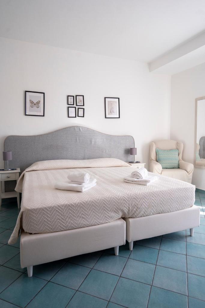 - une chambre blanche avec un grand lit et un canapé dans l'établissement Villa Miramare, piscina e parcheggio a Conca dei Marini, à Conca dei Marini