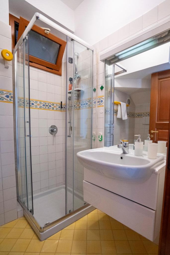une salle de bain avec un lavabo et une douche dans l'établissement Villa Miramare, piscina e parcheggio a Conca dei Marini, à Conca dei Marini