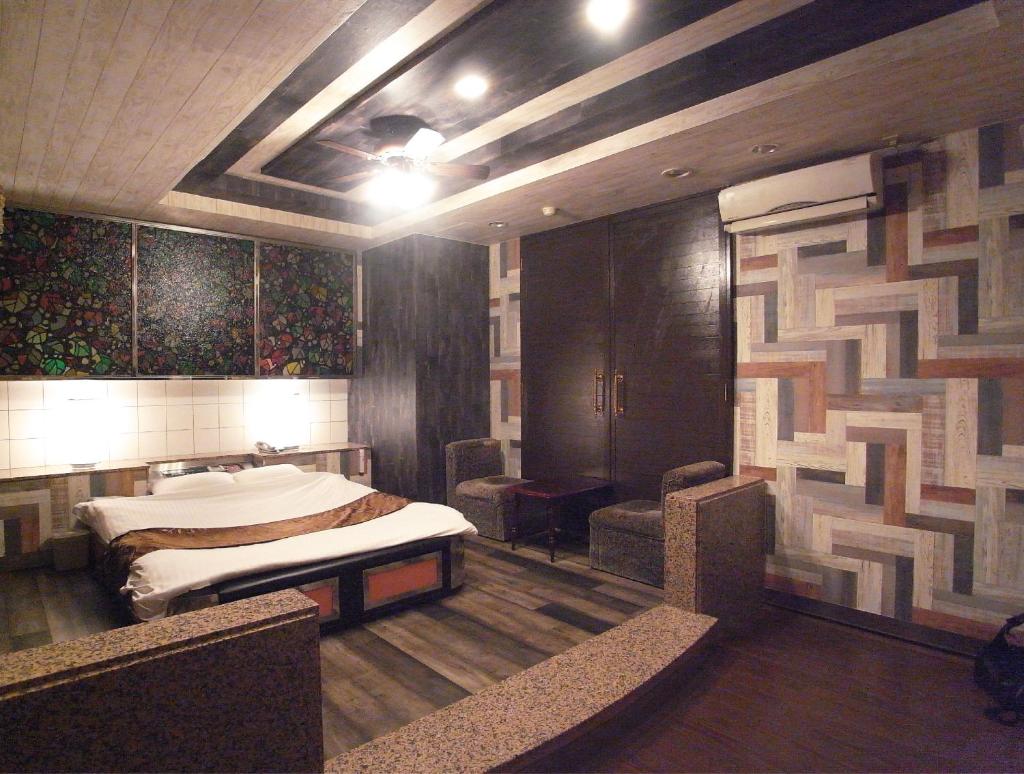 une chambre avec un lit et des chaises dans l'établissement ホテル暴れ狸の鬼袋姫路駅前店 男塾ホテルグループ, à Himeji 18 autres photos