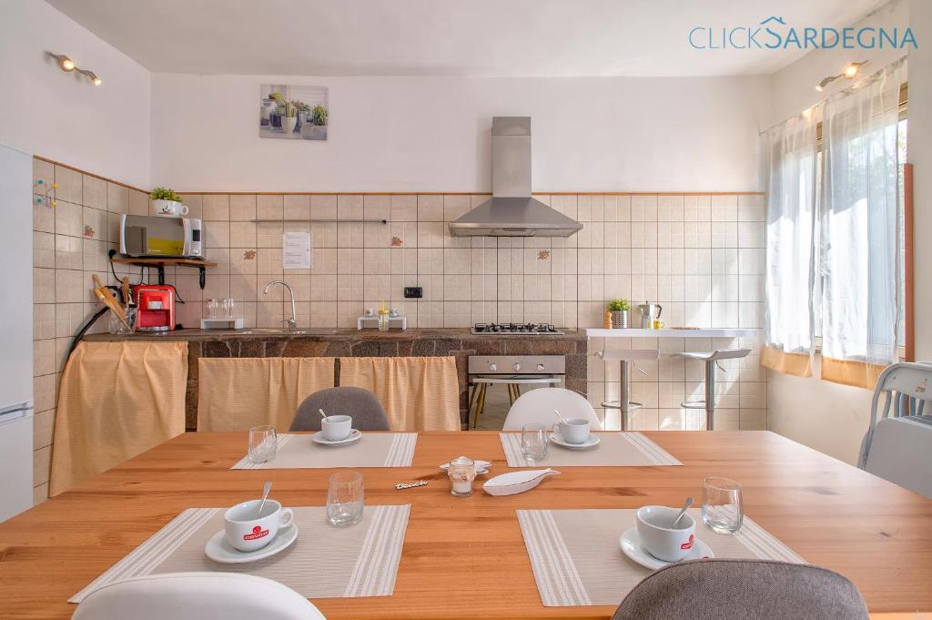 une cuisine et une salle à manger avec une table et des chaises dans l'établissement Villa Melograno with exclusive swimming pool surrounded by greenery, à Campanedda