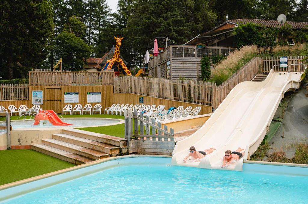 2 personnes sur un toboggan dans un parc aquatique dans l'établissement Glamping Payrac, à Payrac