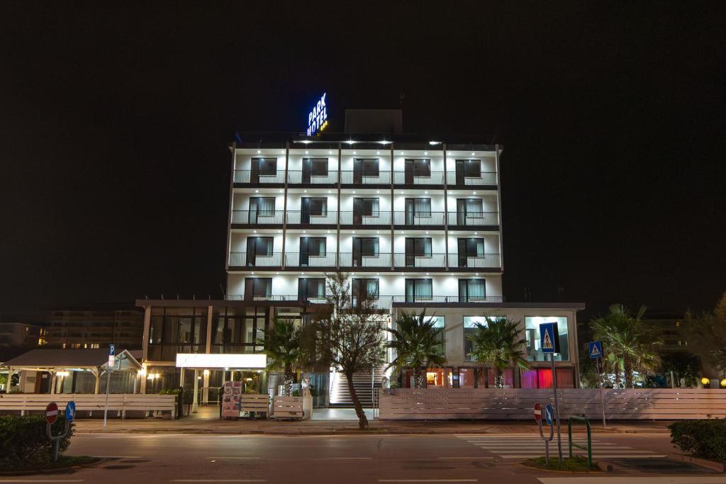 un bâtiment avec un drapeau en haut de celui-ci la nuit dans l'établissement Hotel Park, à Sottomarina