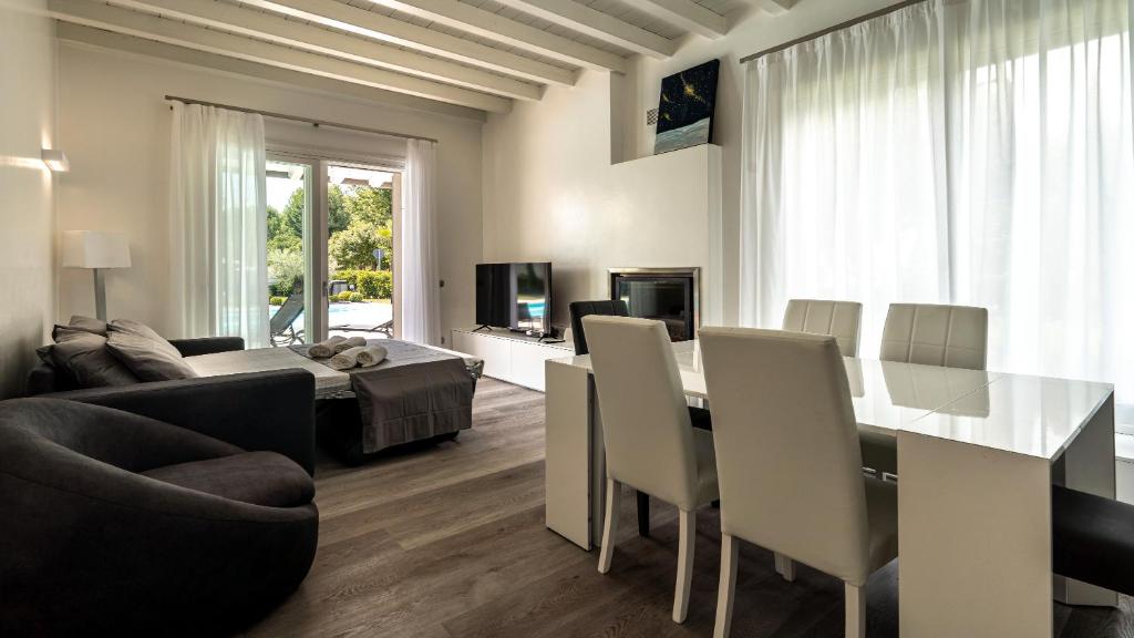 un salon avec une table, des chaises et un canapé dans l'établissement Villa Sirmione Front Lake, à Sirmione