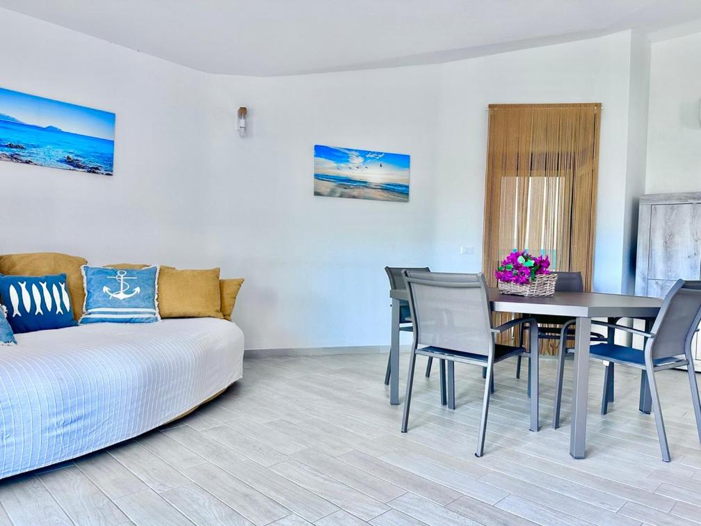 un salon avec un canapé, une table et des chaises dans l'établissement Villa Neni - Key to Villas, à Valledoria