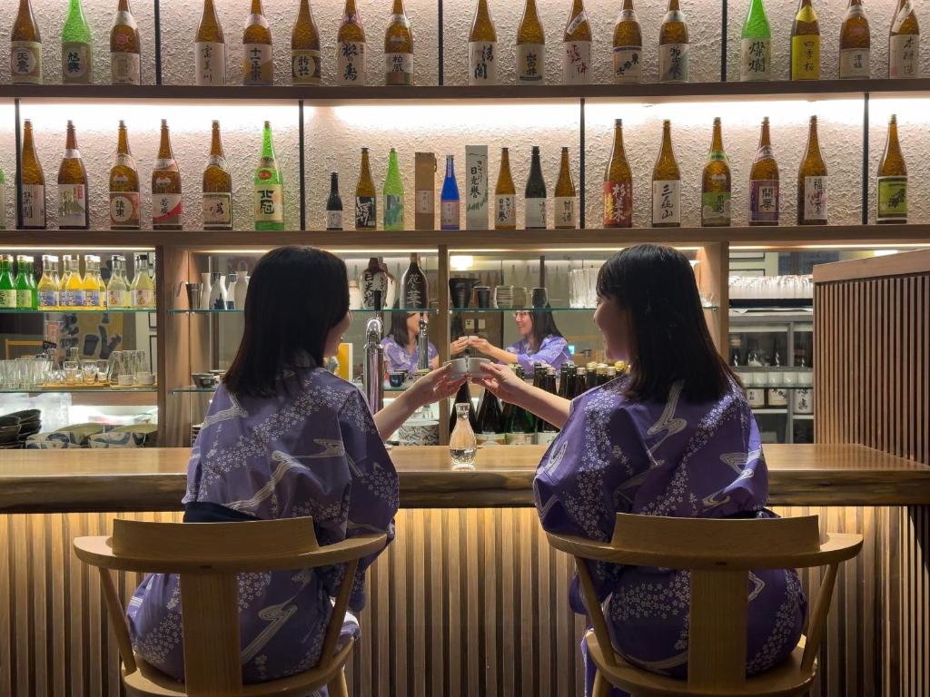 deux femmes assises devant un bar dans l'établissement Hana to Hana, à Nikkō 170 autres photos