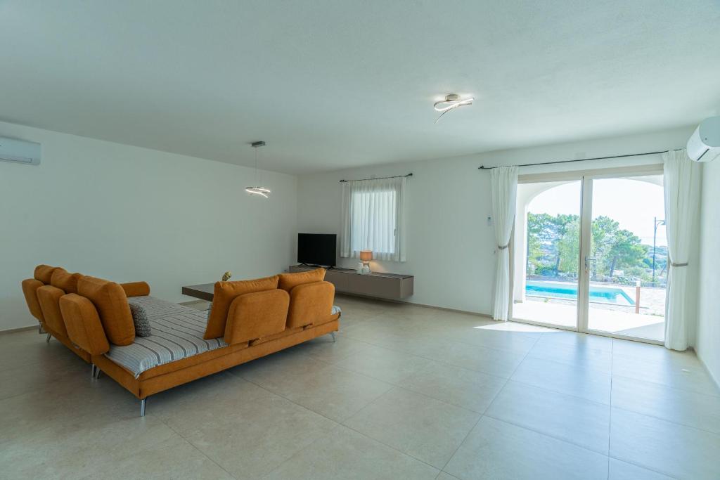 un grand salon avec un canapé et une télévision dans l'établissement Villa Infinity with Pool by Wonderful Italy, à Olbia
