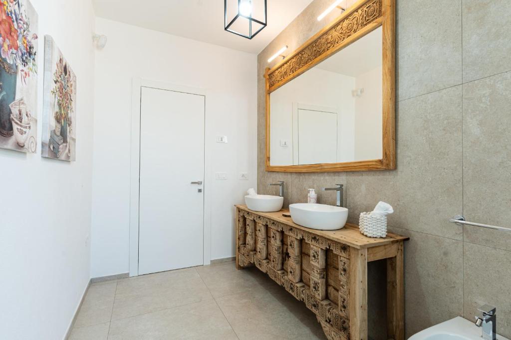 une salle de bain avec deux lavabos et un miroir dans l'établissement Villa Infinity with Pool by Wonderful Italy, à Olbia