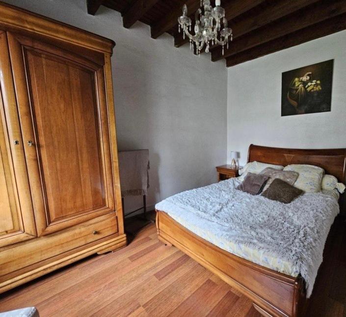 - une chambre avec un lit et une grande armoire en bois dans l'établissement GÎTE VIGNERAIE, à Sainte-Gemme-Moronval 29 autres photos