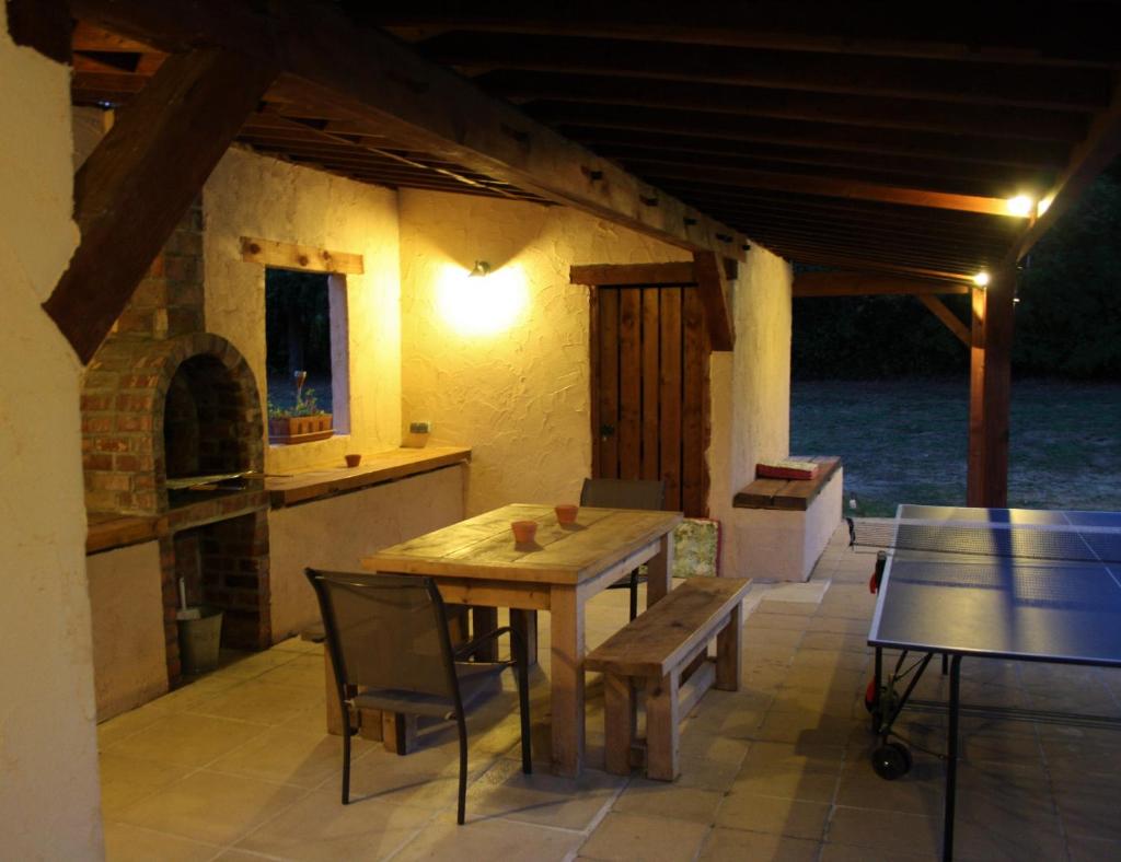 une table et des chaises en bois sur une terrasse dans l'établissement Wisteria Gite, à Asnières-sur-Vègre