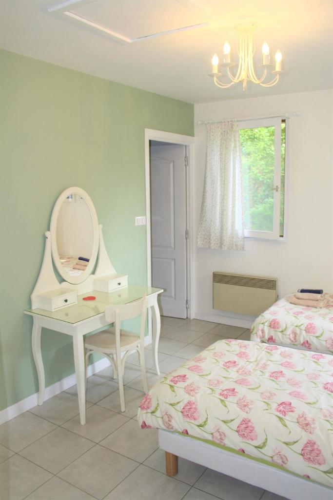 - une chambre avec un lit, une coiffeuse et un miroir dans l'établissement Wisteria Gite, à Asnières-sur-Vègre 13 autres photos
