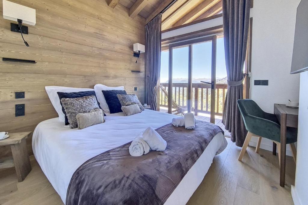 une chambre avec un grand lit avec un bureau et une fenêtre dans l'établissement Les Chalets A11 Meribel, spacious family duplex, 100m from ski lift Les Chalets, à Méribel 11 autres photos