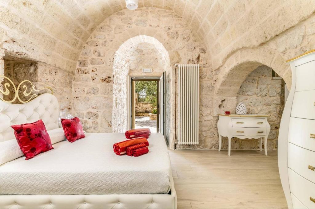 une chambre avec un lit blanc avec des oreillers rouges dans l'établissement Villa Amico by Villa Plus, à Grottaglie