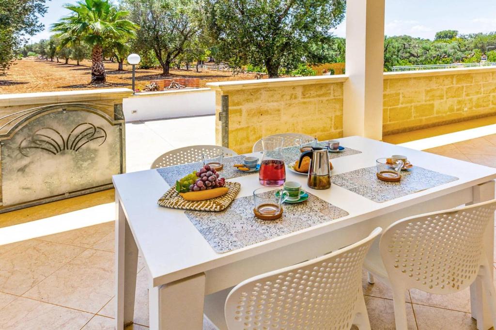 une table blanche avec une assiette de fruits sur elle dans l'établissement Villa Guglielmo by Villa Plus, à Carovigno