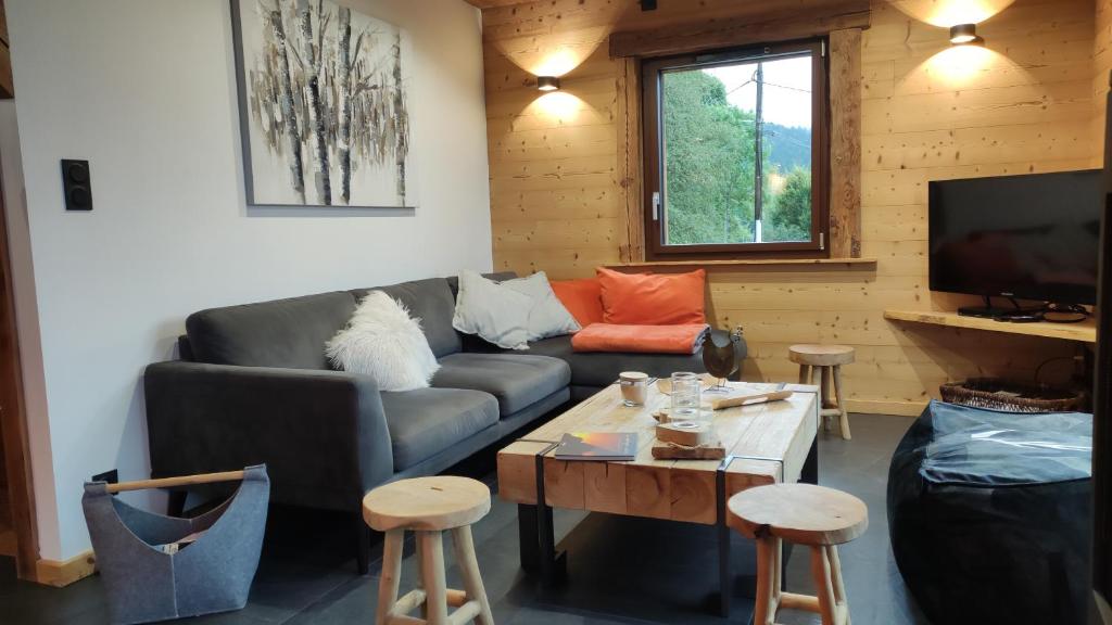 un salon avec un canapé et une table dans l'établissement L'instant chalet Lodge 17, à Gérardmer