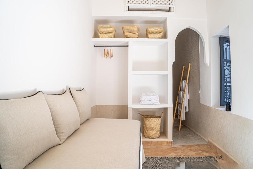- un salon avec un canapé et des étagères dans l'établissement Riad COPAH, à Marrakech