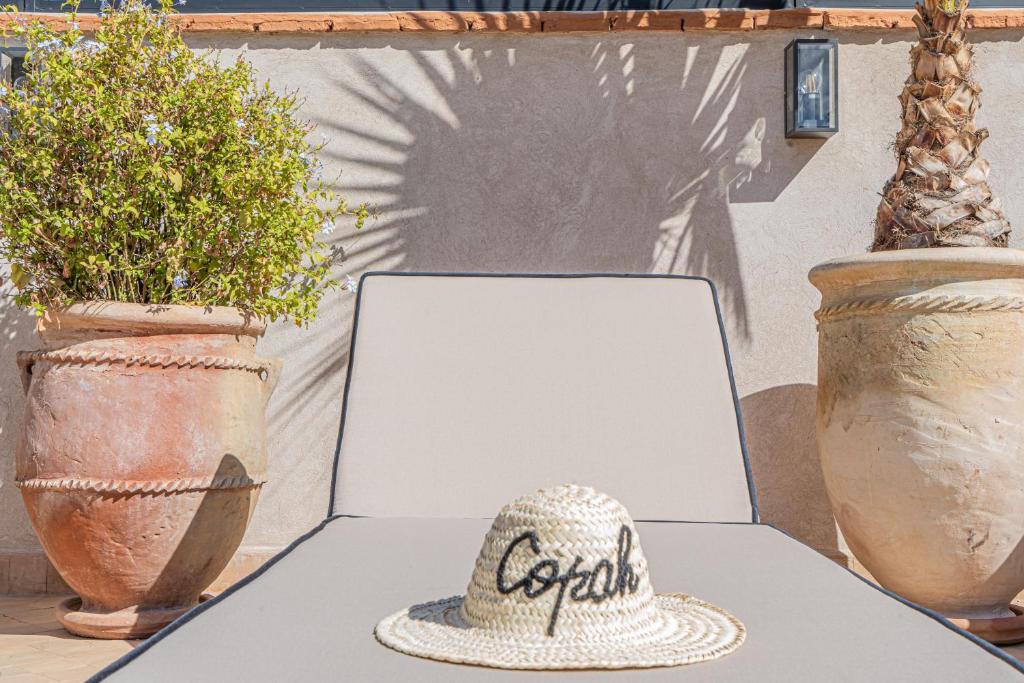 Un chapeau assis sur une table à côté d'un ordinateur portable dans l'établissement Riad COPAH, à Marrakech