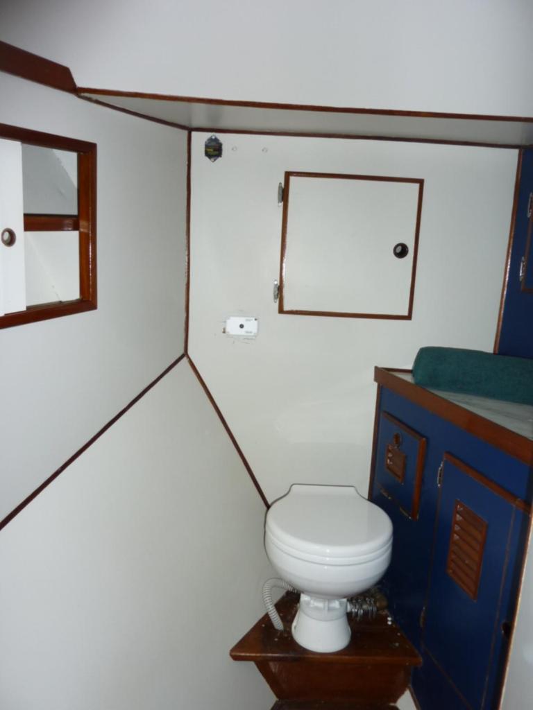 une petite salle de bain avec toilettes et miroir dans l'établissement Bateau PAPAYE, à Sète 6 autres photos