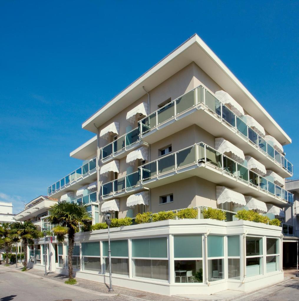 un grand bâtiment blanc avec balcon et plantes dans l'établissement Hotel Consuelo, à Riccione