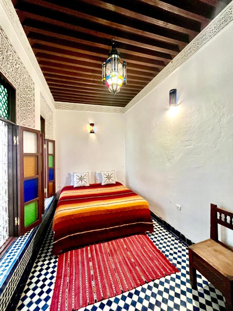 - une chambre avec un lit et un tapis rouge dans l'établissement Dar atlas, à Fès