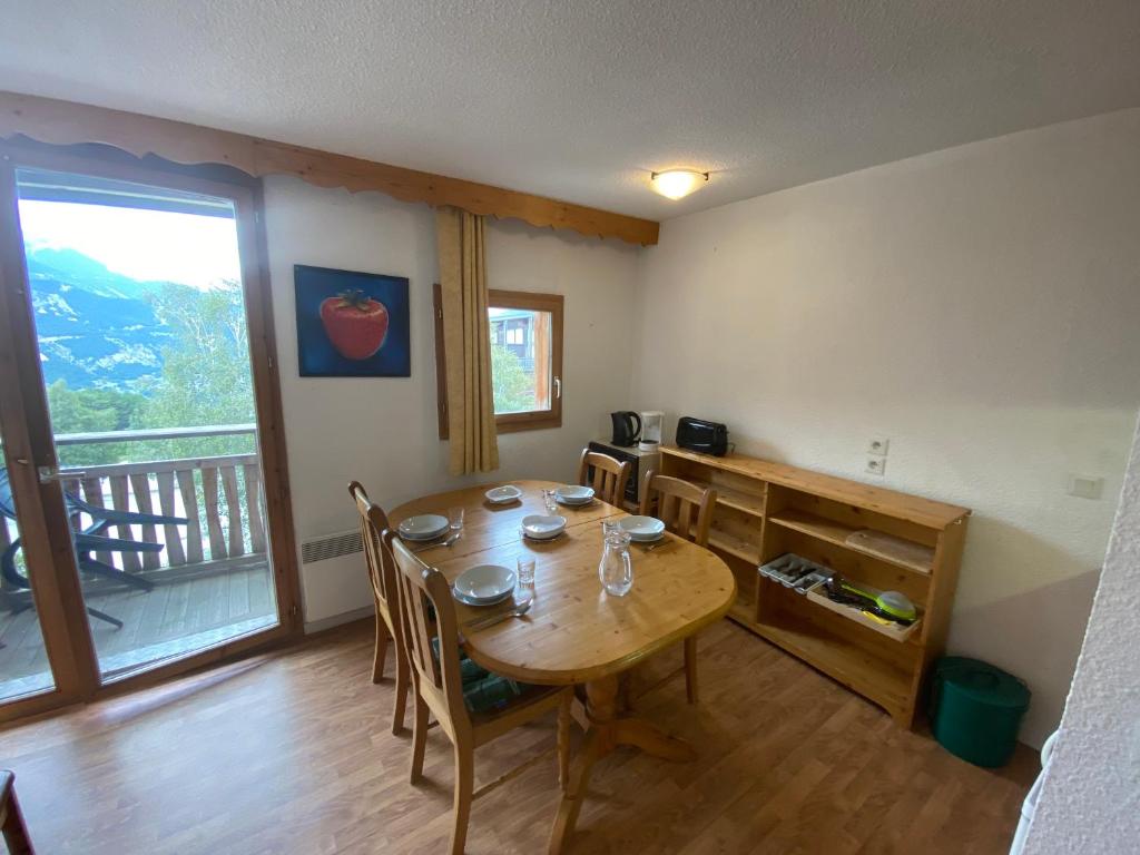 une salle à manger avec une table et des chaises et un balcon dans l'établissement Nid douillet avec superbe vue à 100m des pistes, à Villarodin-Bourget