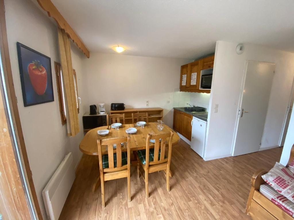 une petite cuisine avec une table et des chaises dans une pièce dans l'établissement Nid douillet avec superbe vue à 100m des pistes, à Villarodin-Bourget 7 autres photos