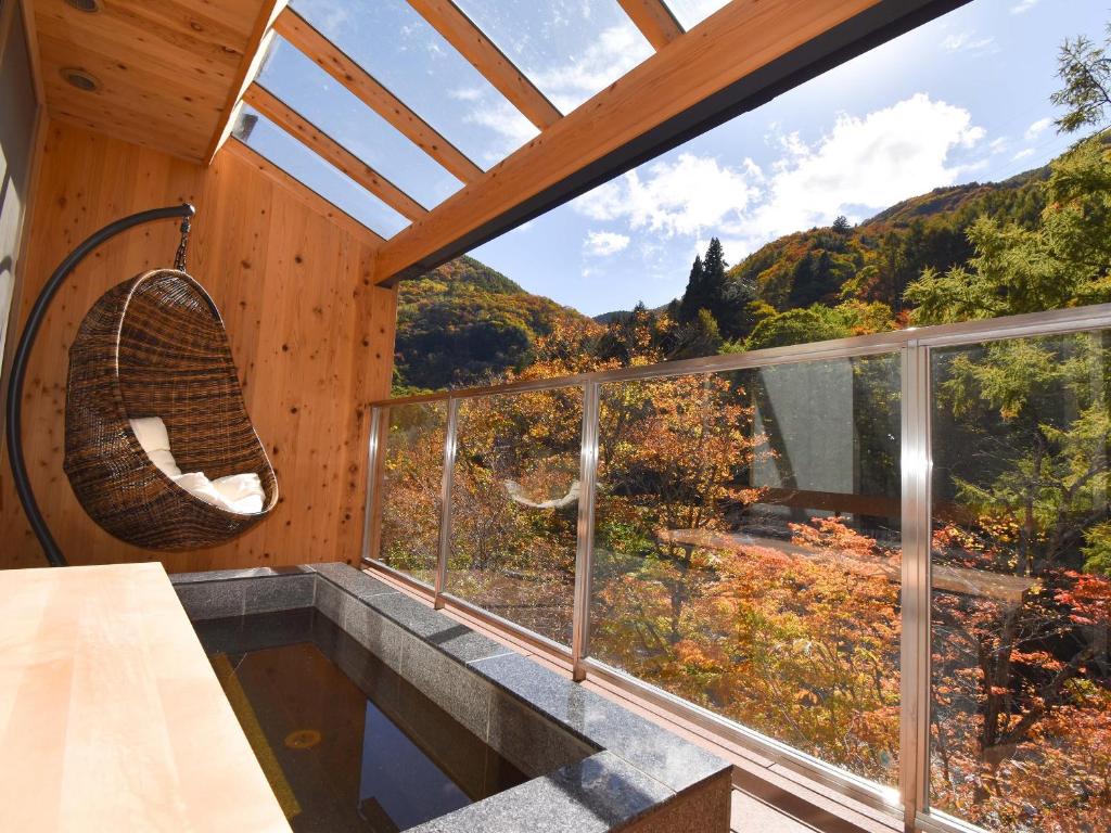une pièce avec une grande fenêtre avec vue sur une montagne dans l'établissement Keiryuso Siorie, à Matsumoto