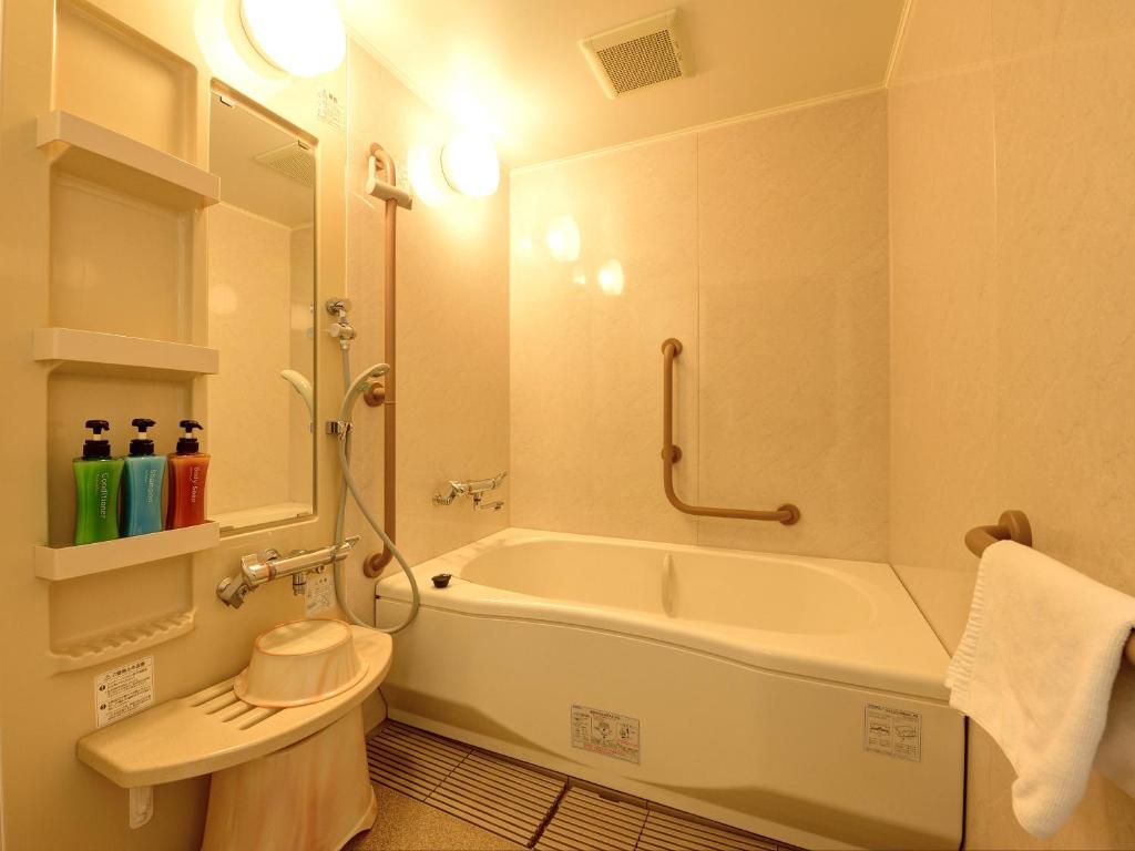 une salle de bain avec une baignoire, des toilettes et un lavabo dans l'établissement Yatsuo Yume no Mori Yuyu kan, à Toyama