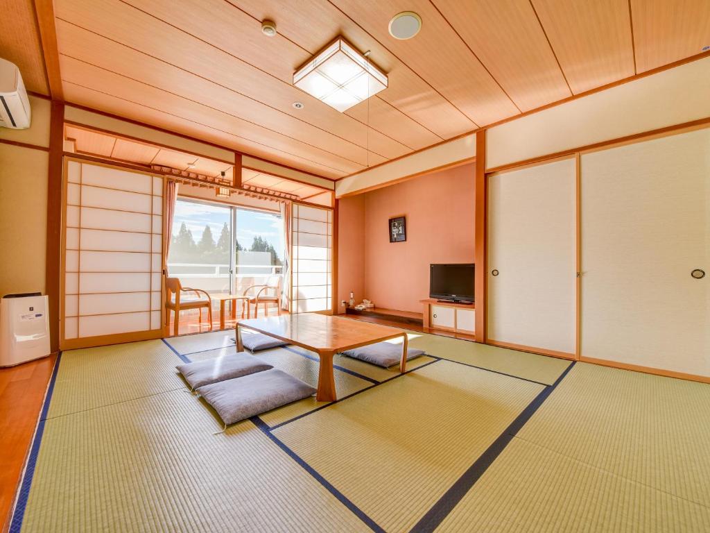 un salon avec une table et une télévision dans l'établissement Yatsuo Yume no Mori Yuyu kan, à Toyama