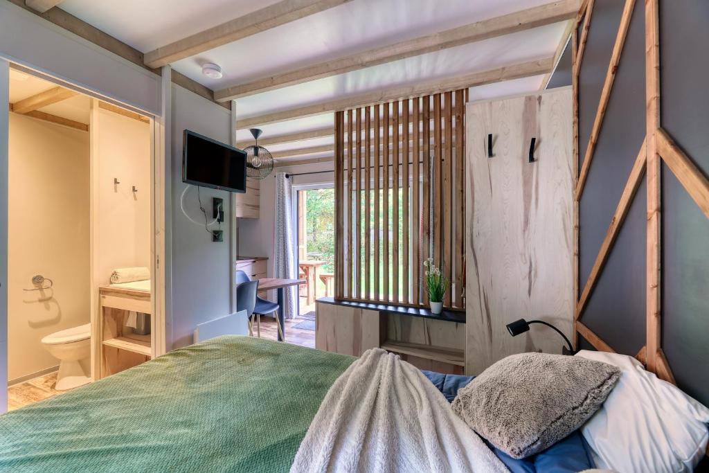 une chambre avec un lit, une télévision et une fenêtre dans l'établissement Nantes Camping Le Petit Port, à Nantes