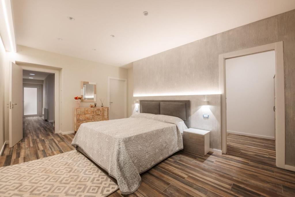 une chambre avec un grand lit et un parquet dans l'établissement Enotria Villas - Villa Vittoria Luxury, à Coccorino
