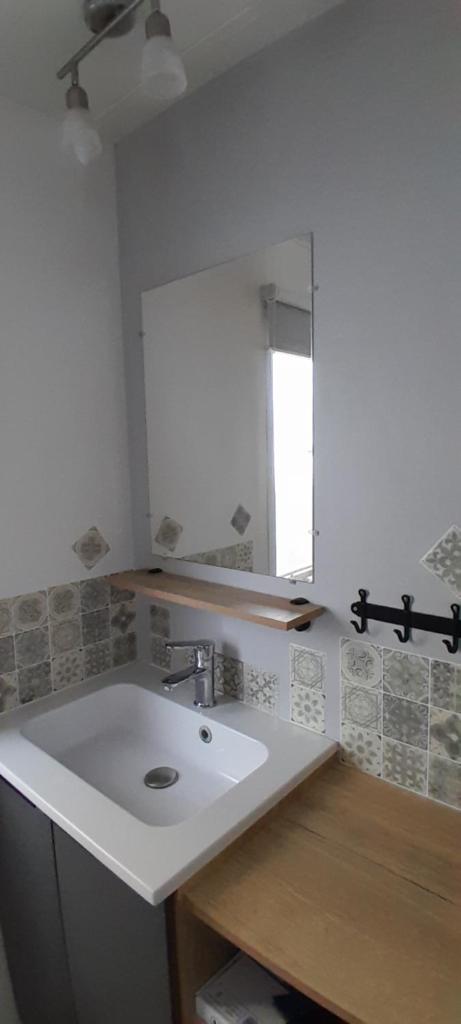 une salle de bain avec un lavabo et un miroir dans l'établissement JOLI MOBILHOME 8 PERS climatisé CA62, à Vias