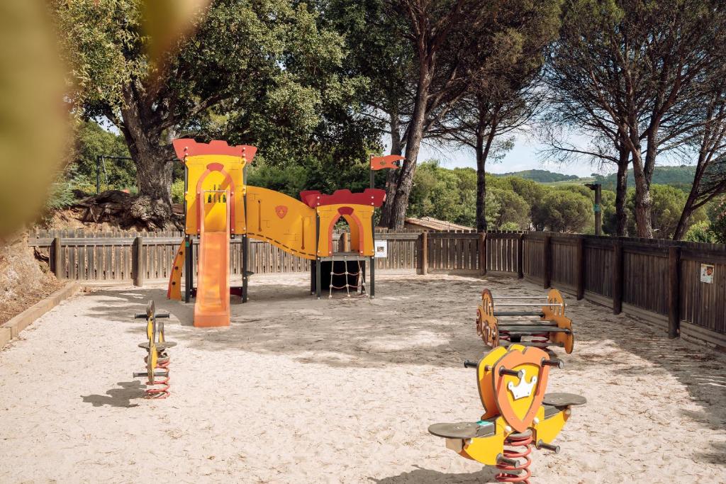 une aire de jeux avec des équipements de jeux jaune et orange dans l'établissement Domaine de Verdagne, à Gassin