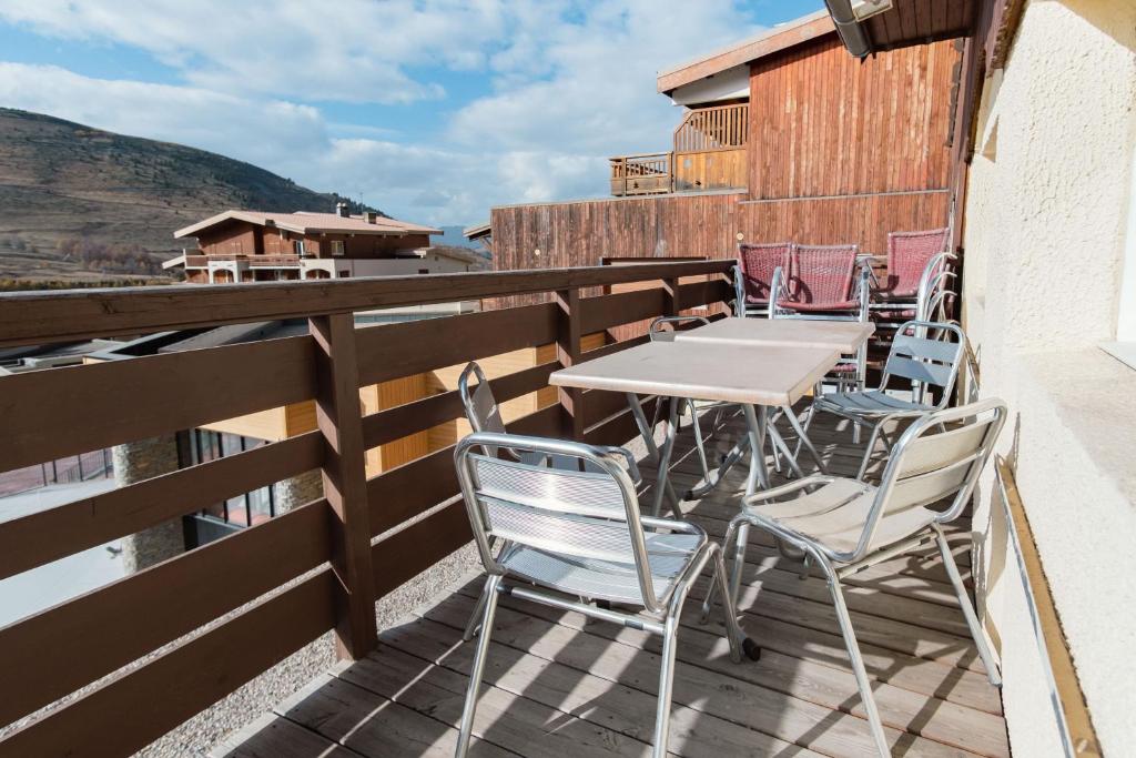 un patio avec une table et des chaises sur un balcon dans l'établissement Superbe appart avec sauna, au pied du télésiège, WiFi, babyfoot, à Les Deux Alpes