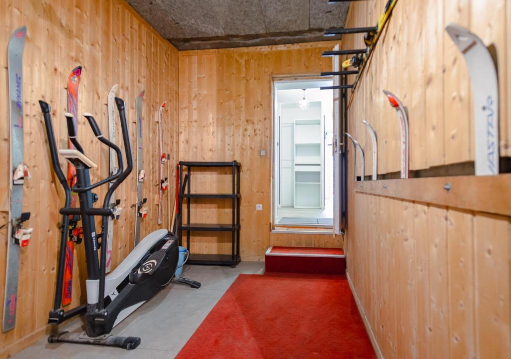 - une salle de sport avec des skis sur le mur et un tapis de course dans l'établissement Superbe appart avec sauna, au pied du télésiège, WiFi, babyfoot, à Les Deux Alpes