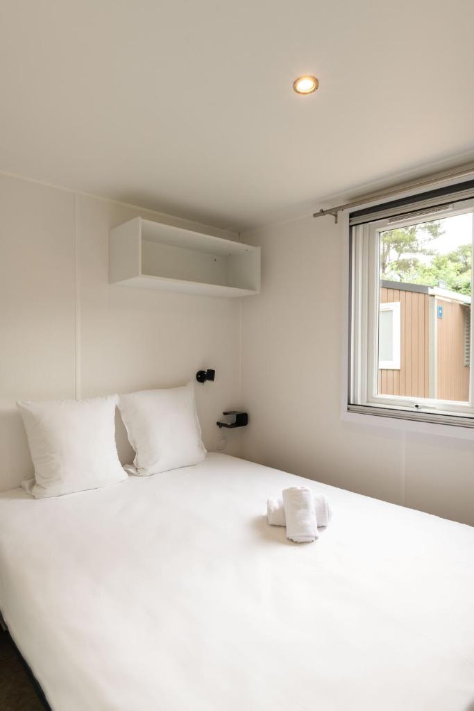 un lit blanc dans une chambre avec une fenêtre dans l'établissement Domaine de Verdagne, à Gassin 33 autres photos
