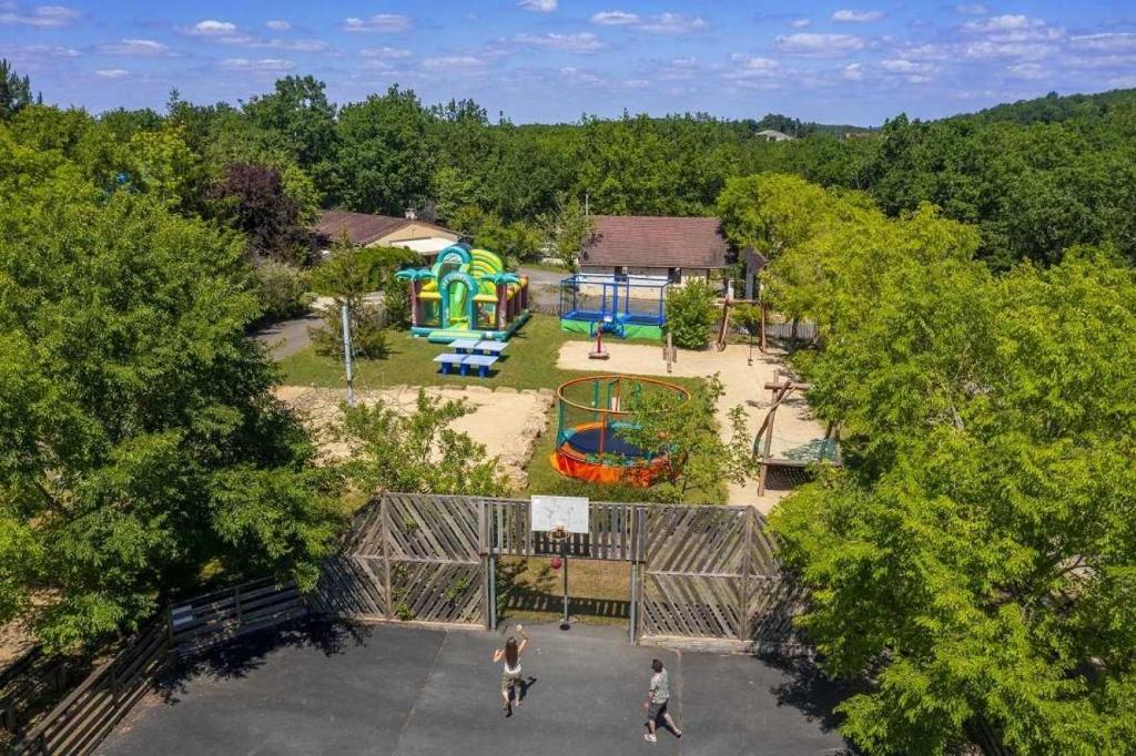 une vue aérienne d'un parc avec une aire de jeux dans l'établissement Camping 4 étoiles - Piscine - eeieab, à Castelnaud-la-Chapelle
