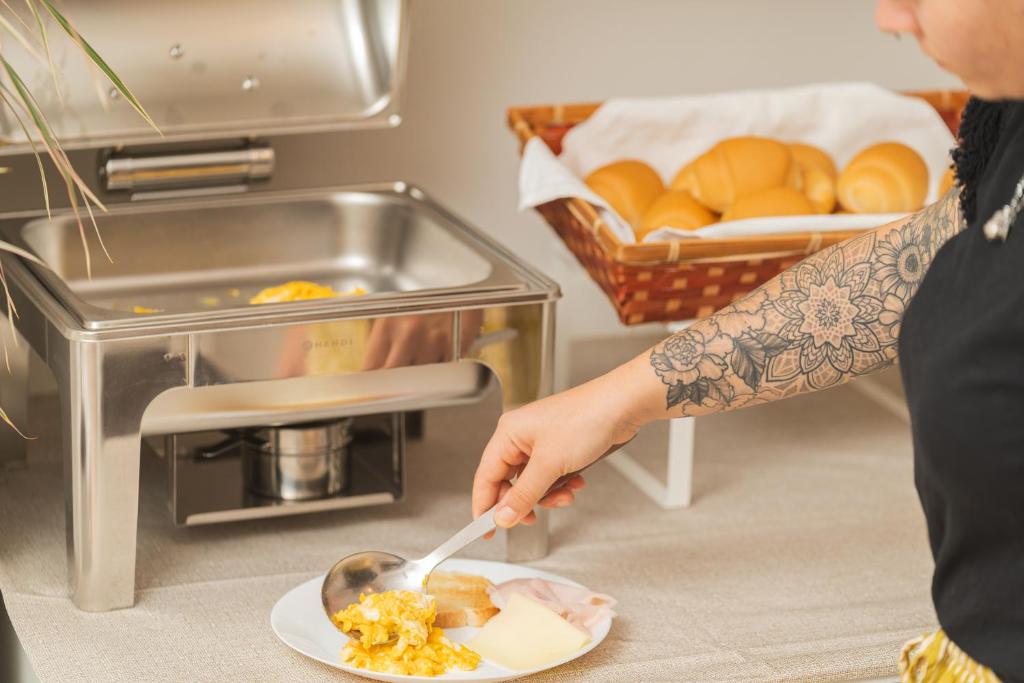 une personne mangeant de la nourriture dans une assiette avec une cuillère dans l'établissement Hotel Ondina e Milazzo, à Cervia