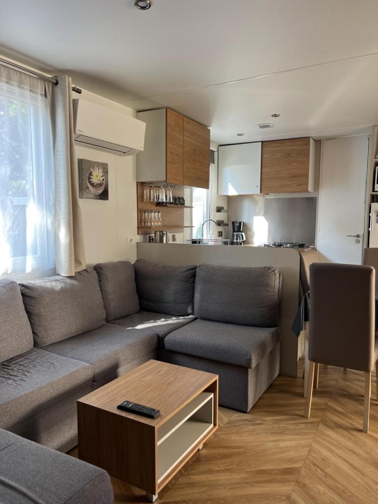 un salon avec un canapé et une table dans l'établissement Camping Del Mar 260, Mobile Home Excellence, 3 chambres, 6 personnes, bord de mer, à Argelès-sur-Mer