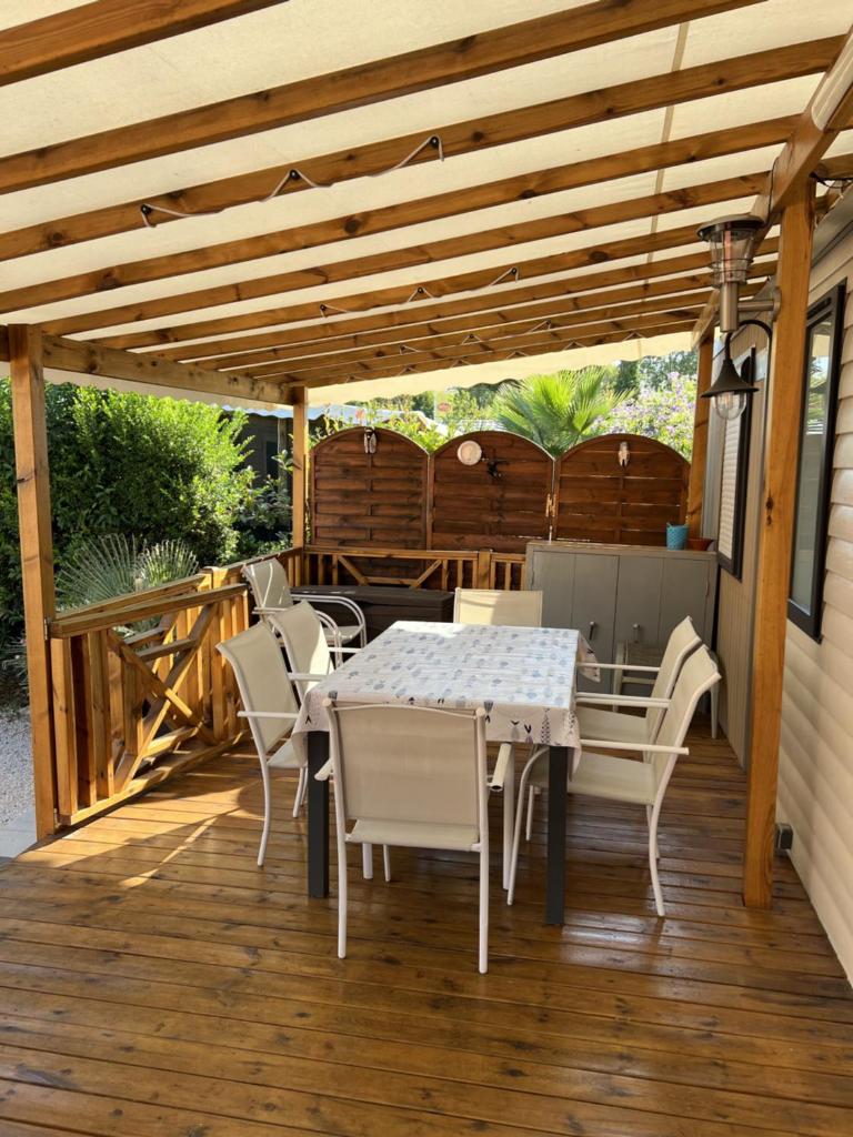 un patio avec une table et des chaises sur une terrasse dans l'établissement Camping Del Mar 260, Mobile Home Excellence, 3 chambres, 6 personnes, bord de mer, à Argelès-sur-Mer