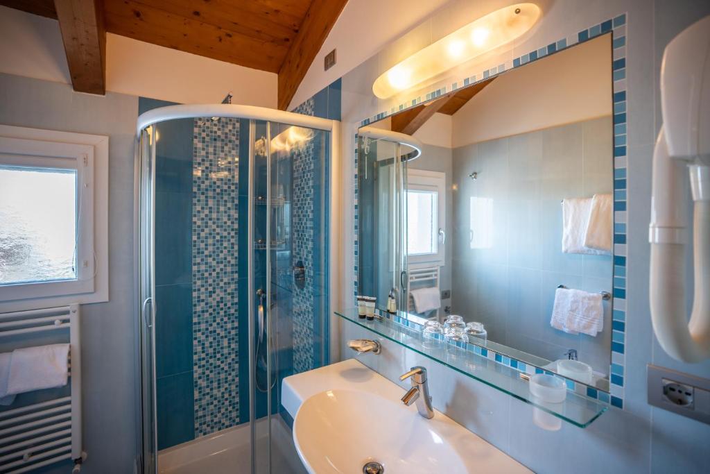 une salle de bain avec un lavabo, une douche et une baignoire dans l'établissement Hotel Coppe Jesolo, à Lido di Jesolo