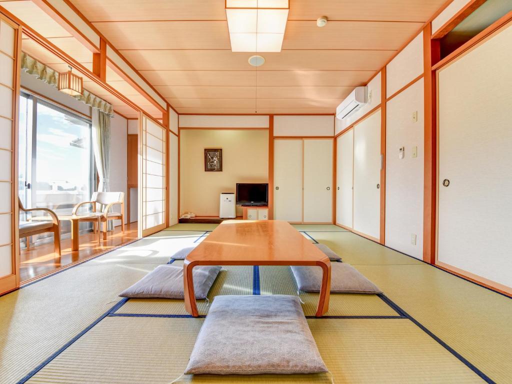 un salon avec une table et des chaises dans l'établissement Yatsuo Yume no Mori Yuyu kan, à Toyama