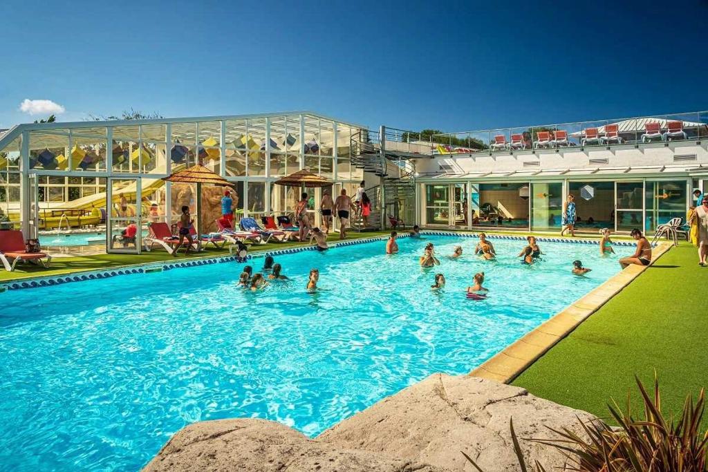 un groupe de personnes dans une piscine dans l'établissement Camping 5 étoiles - Parc aquatique - eei0fd, à Saint-Jean-dʼOrbetiers