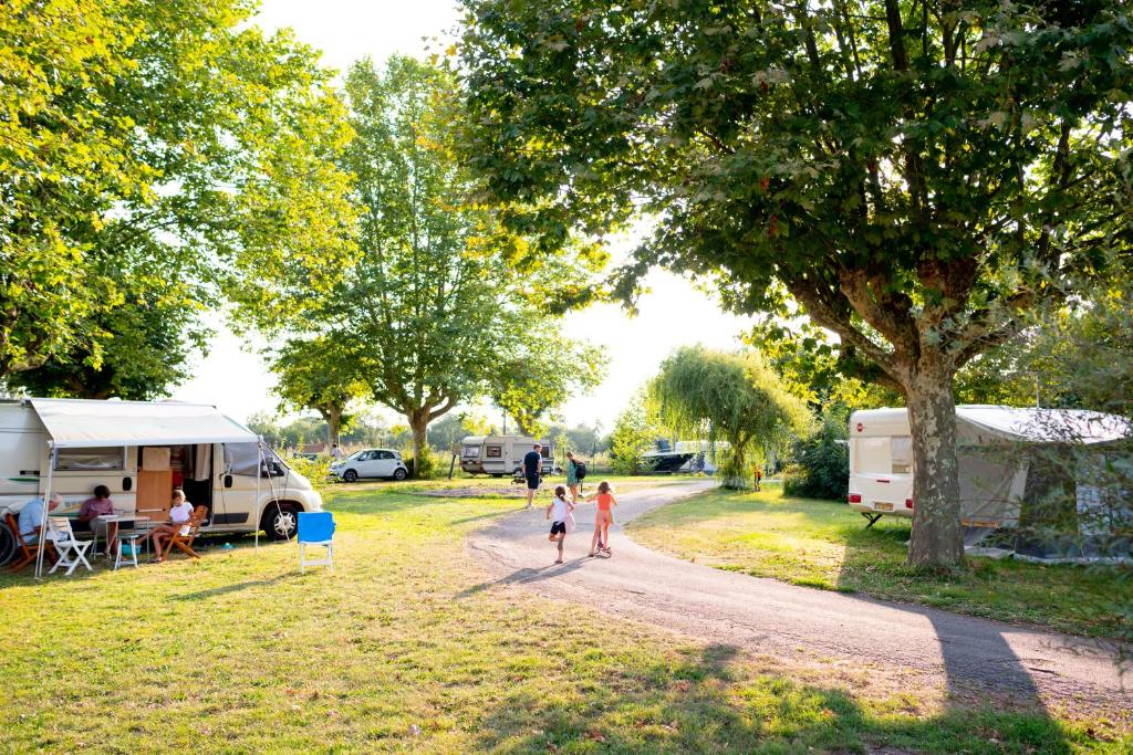 2 enfants marchant sur un chemin de terre à côté d'un terrain de camping dans l'établissement Camping de Thoissey, à Thoissey